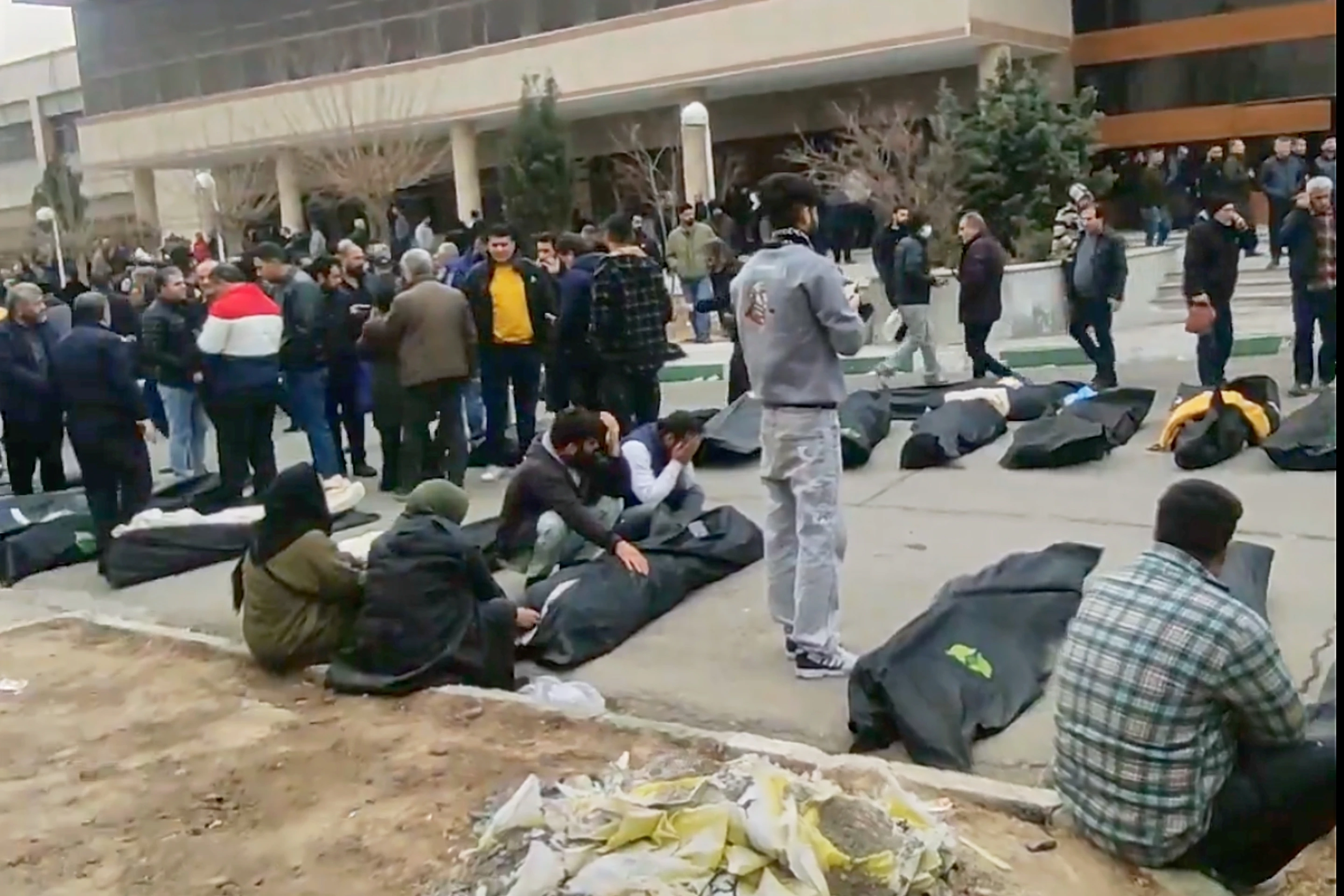 Mourners and rows of bodies at a morgue in Kahrizak, Tehran Province